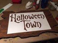 a sign that says halloween town is on a table with other crafting supplies around it