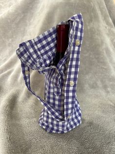 a blue and white checkered shirt with a red wine bottle in the back pocket