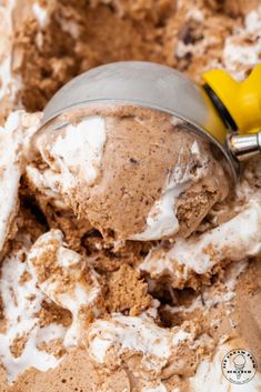 a scoop of ice cream in a bowl with some yellow spoons on the side