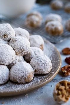 powdered sugar covered donuts on a plate next to nuts and other food items