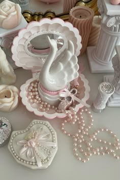 there is a swan on the table with pearls and other items in front of it