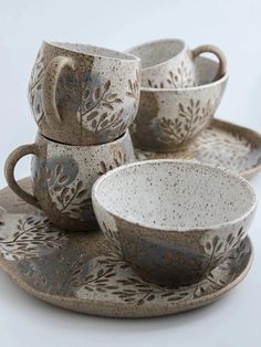 a set of four cups and saucers sitting on top of each other