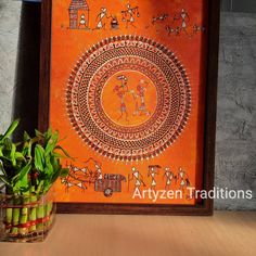 an orange painting on the wall next to a potted plant and vase with bamboo in it