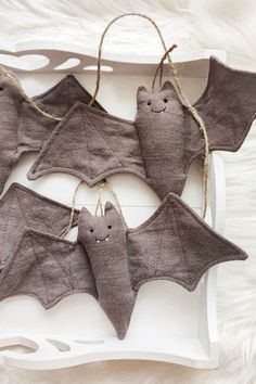 four bats hanging from string on a white tray