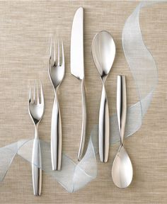 silverware is laid out on a beige surface