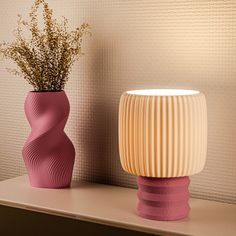 two vases sitting on top of a shelf next to each other with flowers in them