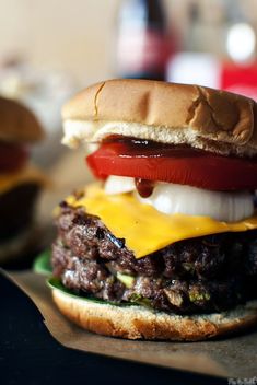 a hamburger with cheese, tomato and onion on it