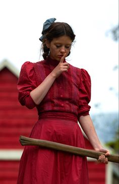 a woman in a red dress holding a stick