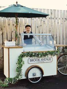 a man standing behind an ice cream cart