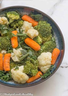 broccoli, cauliflower and carrots in a bowl on a table