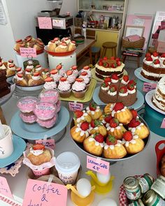 a table topped with lots of cakes and cupcakes covered in frosting on top of plates