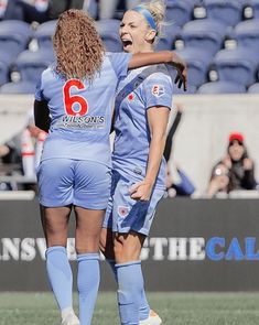 two female soccer players congratulate each other on the field