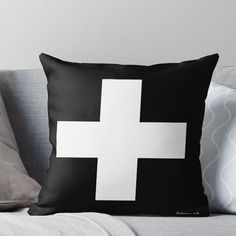 a black and white pillow with a cross on it