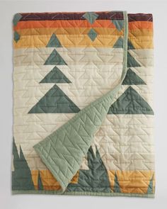 a quilted blanket with trees on it