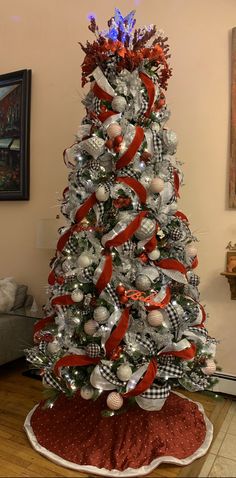 a white christmas tree with red and silver ornaments