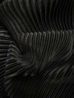 black pleated fabric with wavy lines on the bottom and sides, as if it were folded