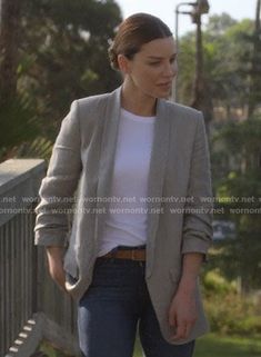 a woman walking across a bridge with her hand in her pocket