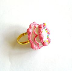 Mini Pink Birthday Cake Ring - Miniature Food Jewelry This adjustable ring features a beautifully detailed pink birthday cake. This tiny little cake was inspired by the classic little girls birthday cake. A round cake frosted with vanilla buttercream and piped pink buttercream edges, Playful Pink Rings For Gifts, Playful Pink Rings Perfect For Gifts, Playful Pink Rings As A Gift, Cute Pink Jewelry For Birthday, Pink Novelty Jewelry For Birthday, Cute Pink Party Rings, Cute Pink Rings For Parties, Sweet Pink Jewelry For Birthday Gift, Cute Pink Round Rings