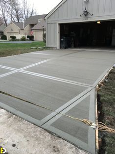 a garage with concrete floors and grass in the front yard