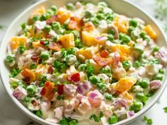 a white bowl filled with peas and fruit salad