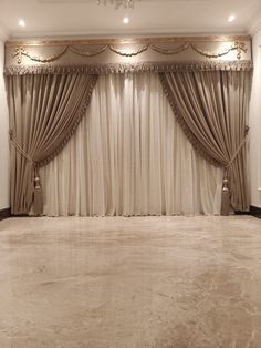 an empty room with curtains and chandelier