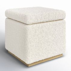 a white ottoman sitting on top of a wooden block