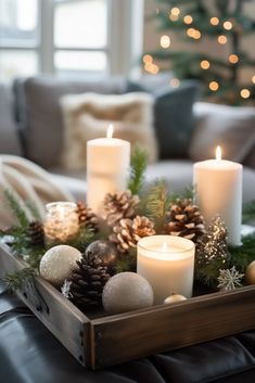 a tray filled with candles and christmas decorations