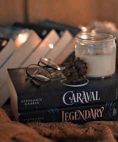 a candle and some books on a bed