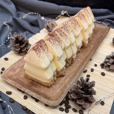 a wooden plate topped with sliced bananas on top of a table next to pine cones