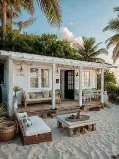 a small white house on the beach with palm trees