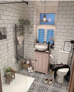 a white toilet sitting next to a sink in a bathroom on top of a black and white floor