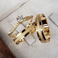 two gold wedding rings with diamonds on them