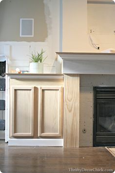 an empty living room with a fireplace and cabinets