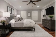 a bedroom with a bed, dresser and television