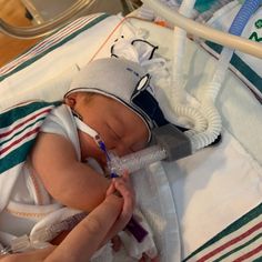 a baby in a hospital bed with an oxygen tube