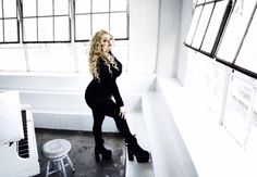 a woman sitting on top of a window sill