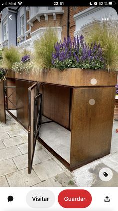 two metal planters with plants growing out of them on the side of a building