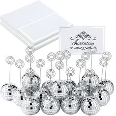 a bunch of silver disco balls sitting in front of a white box with a note on it