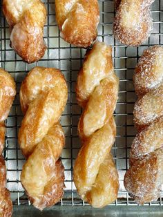 several different kinds of doughnuts on a cooling rack