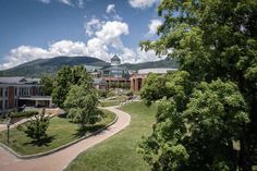 an aerial view of a campus with trees and mountains in the background