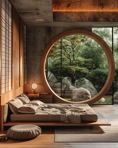 a bedroom with a large circular window in the wall next to a bed and pillows