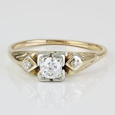 an antique diamond engagement ring in yellow gold and white gold with two diamonds on the band