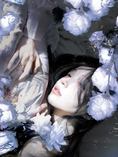 a woman laying in the water surrounded by white flowers