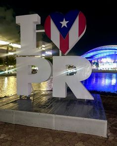 a large sign that says i love puerto next to a body of water at night