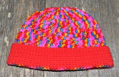 a crocheted hat is laying on a wooden surface