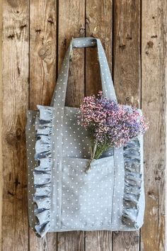 a gray and white polka dot tote bag with purple flowers in the front pocket