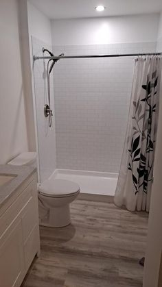 a bathroom with a shower, toilet and sink in it's center piece is shown