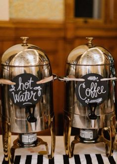 two silver coffee pots sitting on top of a table