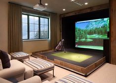 a living room with a golf simulator on the wall