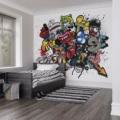 a room with a bed, rug and graffiti wallpaper on the walls in it